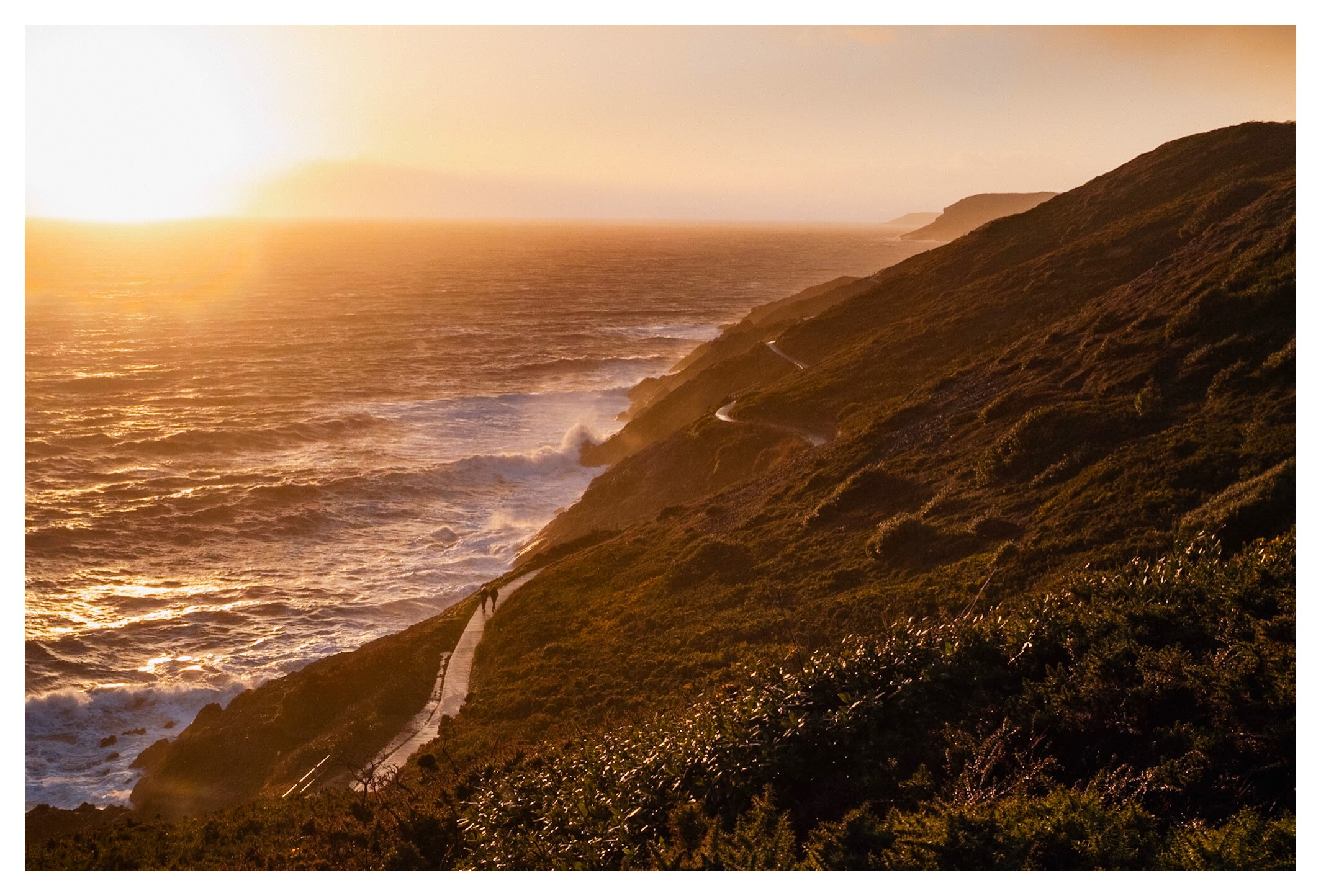 Golden sunset over a coastal path and the sea